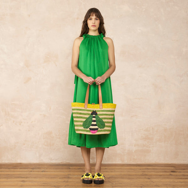 Model wearing the Monday Tote Bag in Bug green Stripe pattern by Orla Kiely